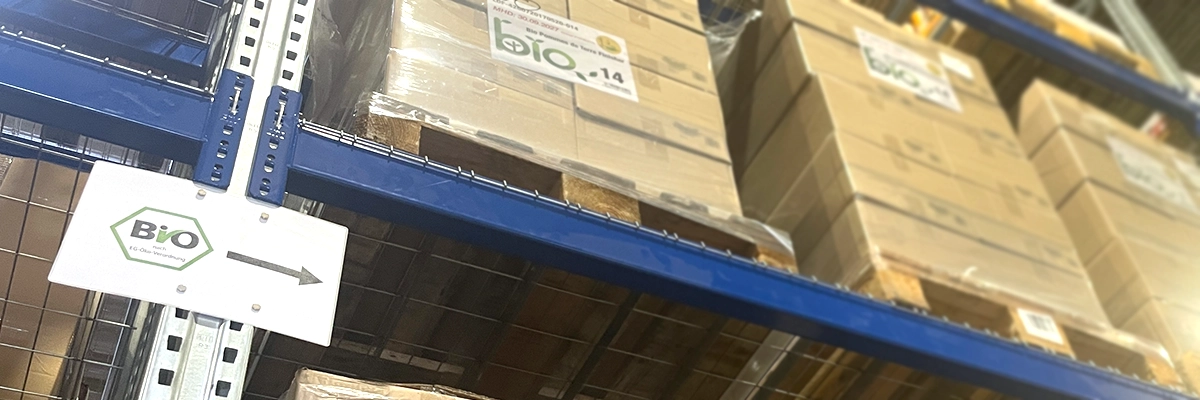 Hinweisschild und Bio-gekennzeichnete Paletten im Lager nach EG-Öko-Verordnung / Fulfillment