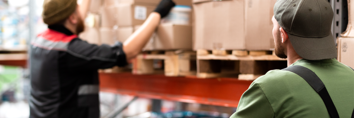 Mitarbeiter in einem Lager bei der Kommissionierung und Verpackung von Kartons im Rahmen der Werbemittel-Logistik im Bereich Fulfillment