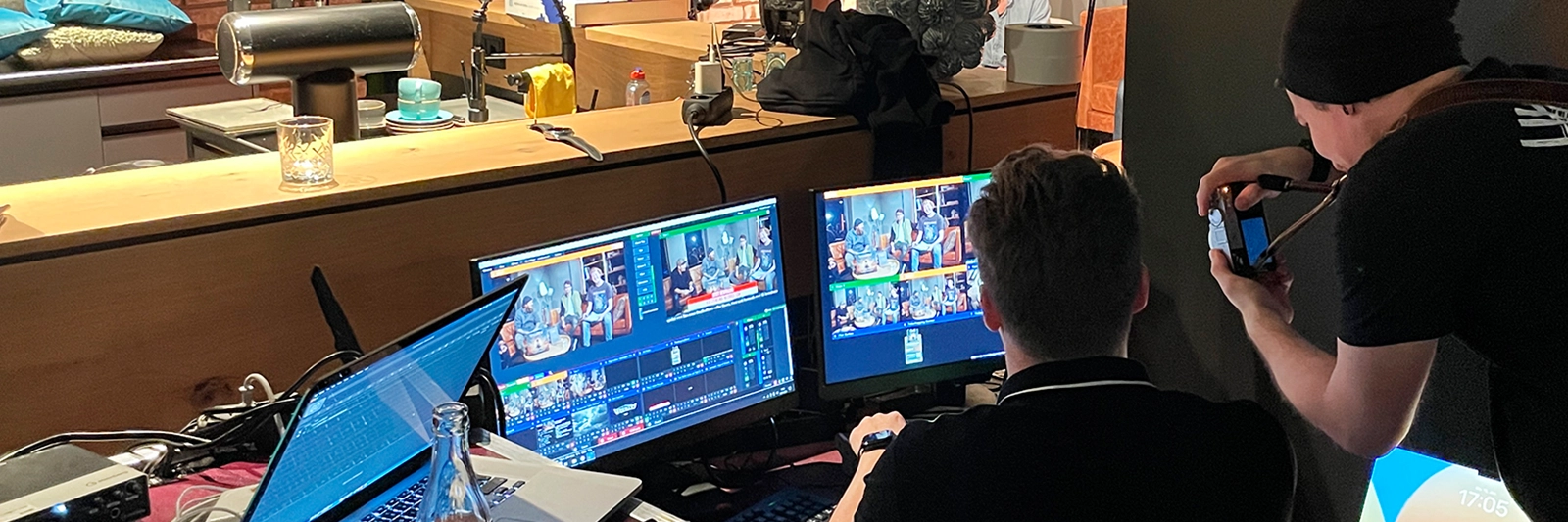 regieplatz waehrend des versengold youtube-lives: mehrere monitore zeigen den livestream, team steuert schnitte und technische ablaeufe